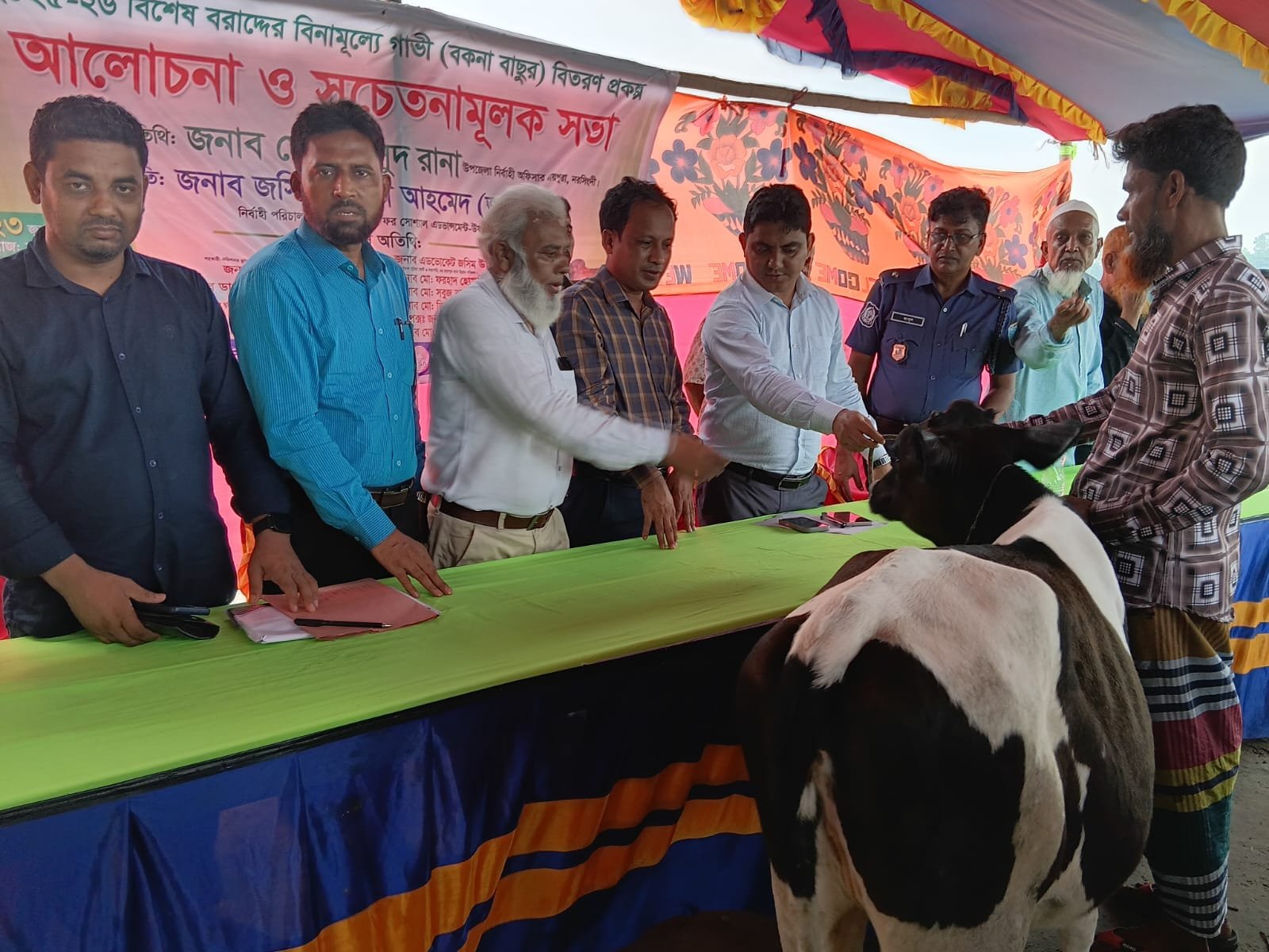 Cow distribution handover, line of officials.